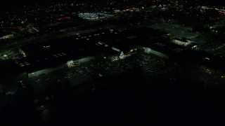 AX155_454E - 5.5K aerial stock footage orbiting the side of Washington Square shopping mall at night in Tigard, Oregon