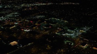 AX155_464E - 5.5K aerial stock footage flying over warehouse buildings, approach Highway 217 and Beaverton Town Square at night, Beaverton, Oregon