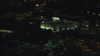 AX155_468 - 5.5K aerial stock footage flying by a six-story parking garage at night, Beaverton, Oregon