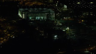 AX155_468E - 5.5K aerial stock footage flying by a six-story parking garage at night, Beaverton, Oregon