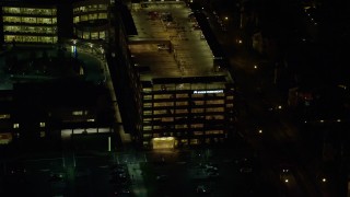 AX155_473 - 5.5K aerial stock footage flying by a hospital parking garage at night in Hillsboro, Oregon