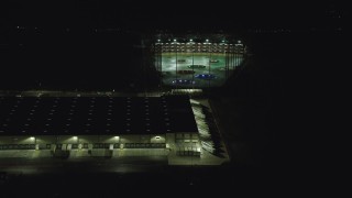 AX155_475 - 5.5K aerial stock footage passing a warehouse building and a Topgolf course in Hillsboro, Oregon at night