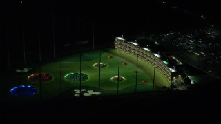 AX155_475E - 5.5K aerial stock footage passing a warehouse building and a Topgolf course in Hillsboro, Oregon at night