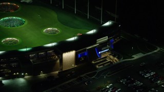 AX155_483 - 5.5K aerial stock footage flying away from the Topgolf course in Hillsboro, Oregon at night