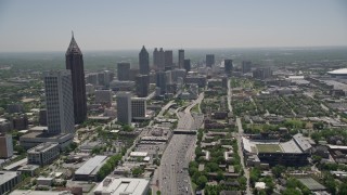 AX36_018E - 4.8K aerial stock footage tilting up from Downtown Connector to reveal skyscrapers, Downtown Atlanta