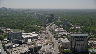 AX36_077E - 4.8K aerial stock footage tilt from a road by office buildings, reveal downtown skyline, Buckhead, Georgia