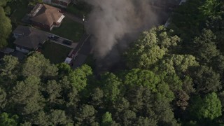 AX38_043E - 4.8K aerial stock footage of smoke rising from a burning home, West Atlanta, Georgia