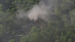 AX38_050E - 4.8K aerial stock footage of smoke rising from a burning home, West Atlanta, Georgia