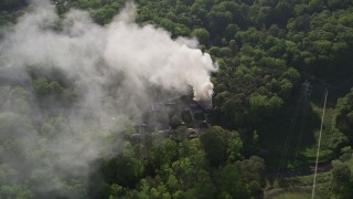 AX38_054E - 4.8K aerial stock footage fly away from smoke, then approach and tilt to bird's eye of a burning house, West Atlanta