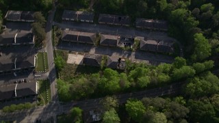 AX38_081 - 4.8K aerial stock footage of a bird's eye orbiting abandoned buildings among trees, Atlanta