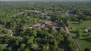 AX38_082 - 4.8K aerial stock footage flying by abandoned buildings among trees, West Atlanta