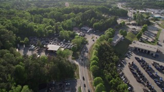 AX38_083 - 4.8K aerial stock footage flying over a parkway and auto parts yard near trees, West Atlanta