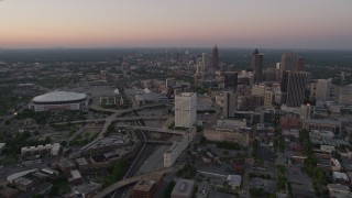 AX40_002E - 4.8K aerial stock footage of Midtown and Georgia Dome seen while approaching Downtown, Atlanta, Georgia, twilight
