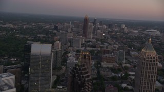 AX40_009E - 4.8K aerial stock footage flying over skyscrapers and office buildings, Midtown Atlanta, Georgia, twilight
