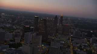 AX40_016E - 4.8K aerial stock footage flying by skyscrapers Downtown Atlanta toward Midtown, Georgia, sunset