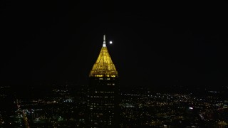 AX41_025E - 4.8K aerial stock footage orbiting Bank of America Plaza revealing moon over Midtown Atlanta, night