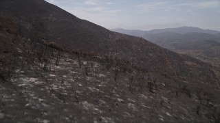 AX42_005E - 5K aerial stock footage fly over mountain slopes of Santa Monica Mountains damaged by wildfires, California