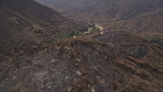 AX42_008 - 5K aerial stock footage fly over scorched ridge of Santa Monica Mountains and approach an isolated rural home, California
