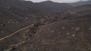 AX42_016 - 5K aerial stock footage follow and pan across a mountain road through fire-ravaged Santa Monica Mountains, California