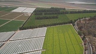 AX42_023 - 5K aerial stock footage fly over crops and greenhouses to approach South Lewis Road, Camarillo, California