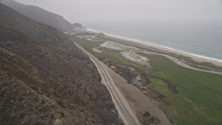AX42_054E - 5K aerial stock footage of following coastal Highway 1 with light traffic toward the ocean, Point Mugu, California