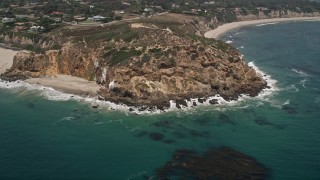 AX42_095 - 5K stock footage aerial video tilt from the ocean to reveal and approach the rugged cliffs of Point Dume, Malibu, California