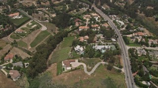 AX42_096 - 5K aerial stock footage tilt to a bird's eye view of mansions and vineyards in the hills, Malibu, California