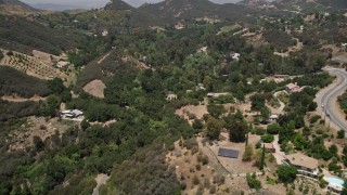 AX42_098E - 5K aerial stock footage fly over Kanan Dume Road to approach hillside mansions in Malibu, California