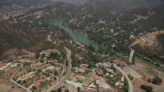 AX42_112E - 5K aerial stock footage fly over spacious upscale homes to approach Malibu Lake, Agoura Hills, California