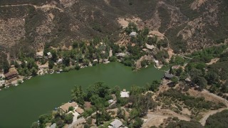 AX42_114 - 5K stock footage aerial video fly over Malibu Lake and tilt to lakefront homes on the shore, Agoura Hills, California
