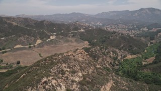 AX42_115 - 5K aerial stock footage fly over Santa Monica Mountains to approach Mulholland Highway, California