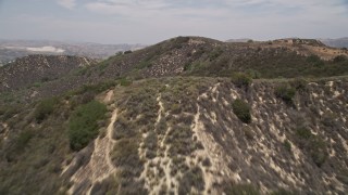 AX42_116E - 5K aerial stock footage of flying low over ridges in the mountains, Santa Monica Mountains, California