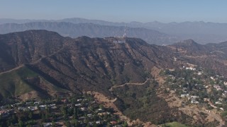 AX43_008 - 4K aerial stock footage tilting from the Hollywood Reservoir to reveal and approach the Hollywood sign, Los Angeles, California