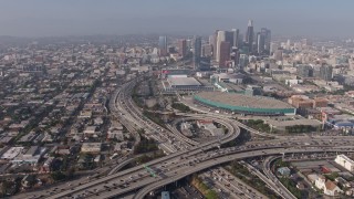 AX43_021 - 4K aerial stock footage orbiting heavy traffic in the 110/10 interchange, and tilt to reveal the Los Angeles Convention Center and skyscrapers, Downtown Los Angeles, California
