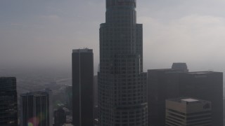AX43_027 - 4K aerial stock footage flying by US Bank Tower, and over City National Plaza and Paul Hastings  Tower on a foggy day, Downtown Los Angeles, California