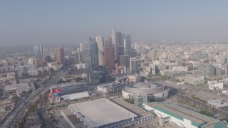 AX43_034 - 4K stock footage aerial video tilting from heavy rush hour traffic on I-110 to reveal Staples Center, Ritz-Carlton and Downtown Los Angeles skyscrapers in California