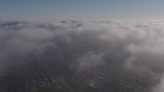 AX43_047 - 4K aerial stock footage flying over a dense marine layer over Los Angeles, California
