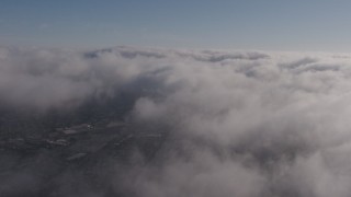 AX43_048 - 4K aerial stock footage flying above marine layer with occasional breaks in the clouds, Los Angeles, California