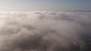 AX43_057 - 4K aerial stock footage panning across marine layer clouds over Los Angeles, California