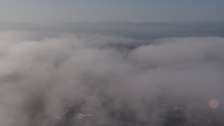 AX43_058 - 4K aerial stock footage flying over marine layer clouds over Beverly Hills, California