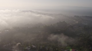 AX43_060 - 4K aerial stock footage approaching the marine layer rolling over upscale, hillside homes in Beverly Hills, California
