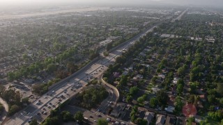 AX43_066 - 4K stock footage aerial video tilting from a bird's eye view of heavy traffic on I-405 to reveal and pan across suburban neighborhoods, Van Nuys, California