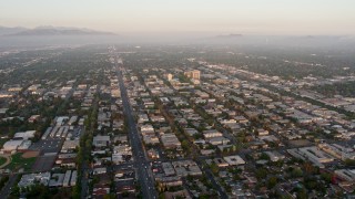 AX44_001 - 4K aerial stock footage flying by urban neighborhoods in Van Nuys, California, sunset