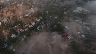 AX44_007 - 4K aerial stock footage flying over homes with a marine layer, Studio City, California