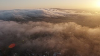 AX44_008E - 4K aerial stock footage of the marine layer over hills, Studio City, California, sunset