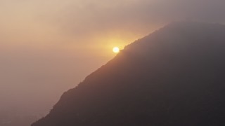AX44_025 - 4K aerial stock footage of the setting sun through the marine layer, Hollywood Hills, California