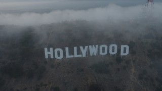 AX44_027 - 4K aerial stock footage flying through marine layer revealing Hollywood Sign, California, sunset