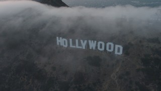 AX44_028 - 4K aerial stock footage orbiting Hollywood Sign covered in marine layer, California, sunset