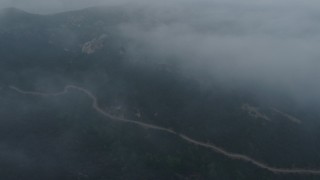 AX44_029 - 4K aerial stock footage of winding roads in fog, Hollywood Hills, California, sunset