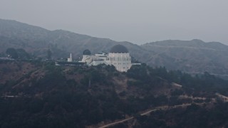 AX44_034 - 4K aerial stock footage orbiting Griffith Observatory in fog, Los Angeles, California, sunset